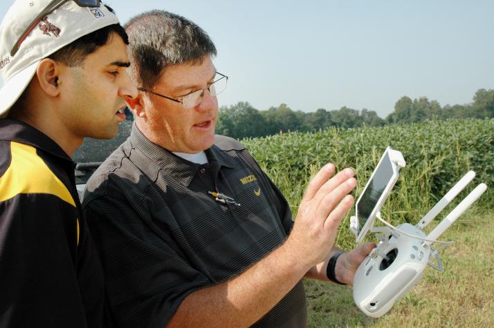 Kent Shannon, right, profiled by Successful Farming magazine’s November 2017 issue as an ‘exceptional extension specialist,’ shows agronomy specialist Dhruba Dhakal how to use a drone to take aerial images of a soybean field in the Missouri Strip Trial PrPhoto by Linda Geist