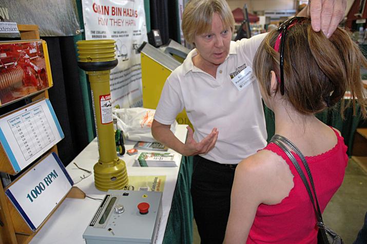 During the Missouri State Fair, MU Extension safety specialist Karen Funkenbusch tells  a young woman that she should pull her long hair up and under a hat when working around farm equipment, especially power take-off devices that can grab hair and clothiLinda Geist photo