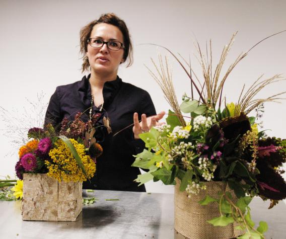 Kim Martin of Tiger Garden shows a fall centerpiece made for less than $10 from weeds, leaves and greenery gathered from her backyard.  By comparison, the centerpiece on the left retails for about $50.Photo by Linda Geist