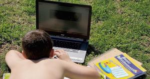 Kolton Kleeman does schoolwork on rented pasture so he can connect his laptop to the internet. 