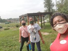 Julia Ho, left, of Solidarity Economy St. Louis and Saundi Kloeckener, center, of Native Women’s Care Circle help Erica Williams, right, tend the gardens at the North County Agricultural Education Center. Photo courtesy A Red Circle.