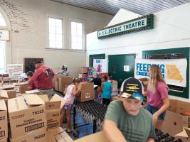 4-H'ers and volunteers pack food boxes at the 2021 Missouri State Fair. The boxes were delivered to the Food Bank for Central & Northeast Missouri.
