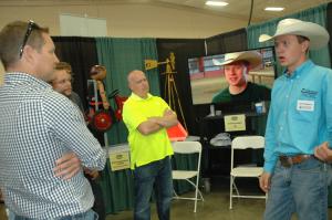 Zane Volkmann (right) talked about helmet safety with state labor and safety officials at the Missouri State Fair. A video about Volkmann's participation in the AgrAbility program availability through University of Missouri Extension plays in the backgrou