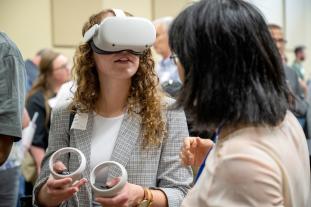 Riley Burke, workforce development associate with EquipmentShare, tests out a virtual reality recruitment game, developed by Mizzou Engineering faculty, at the May 18 MU Career Accelerator kickoff.