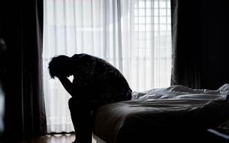 Sad man sitting on bed