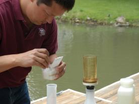 Lakes of Missouri Volunteer Program coordinator Tony Thorpe prepares to suction lake water through a filter. University of Missouri researchers will analyze the filters for sediment and chlorophyll.University of Missouri