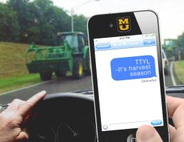 Driver texting while driving near farm equipment