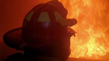 man in fire suit looking at fire