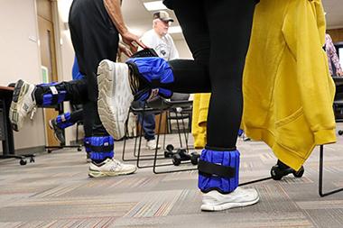 Standing behind a chair with weights on your ankles and lifting one foot for balance