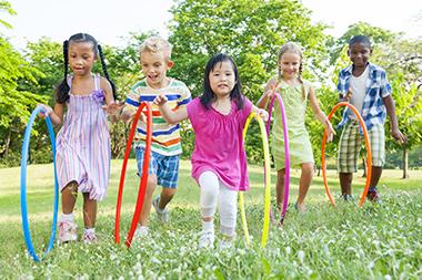 children running with hula hoops