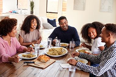 Family eating a home cooked meal around their dining table