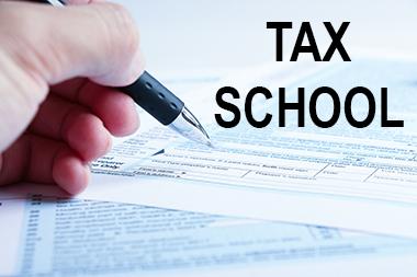 Hand filling out tax form for tax school