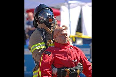 A firefighter pulling a dummy out of harm in a demonstration training.