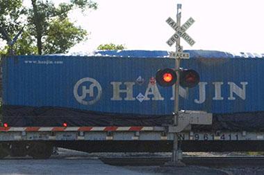 Train on a track behind a crossing bar.