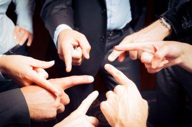 Workers in suits pointing at each other