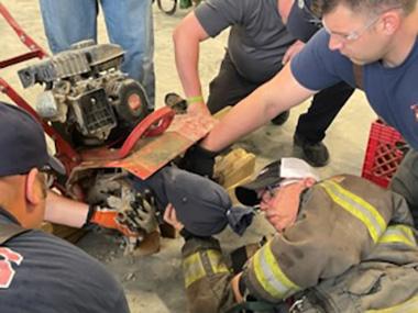 Firefighters practicing extraction from a tiller.