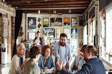 A group of people talking at a table.