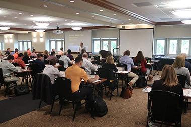 Conference room full of attendees listening to presentation on agriculture topic