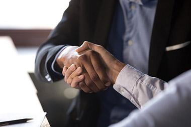 Close-up of handshake between 2 people in business attire