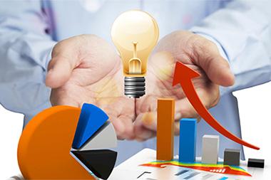 Charts and a lightbulb with a man's open hands