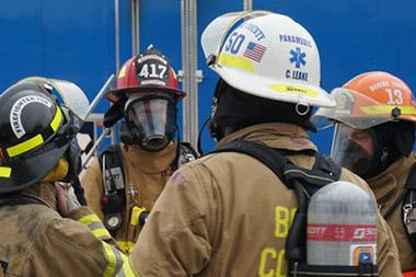 Firefighters in uniforms and gear discussing plans