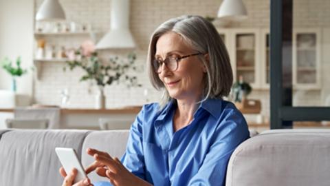 older woman using a phone with a smile