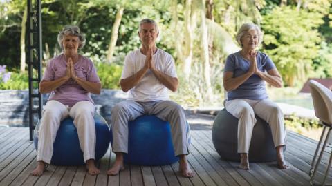 three seniors doing chair yoga
