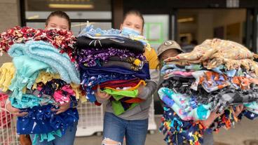 children holding tie blankets