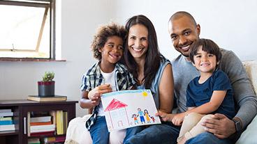 Family with child holding up drawing