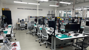 Open space with mulitple stations with monitors, keyboard and more.