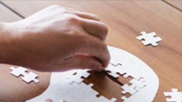 hand putting pieces into a puzzle-shaped head