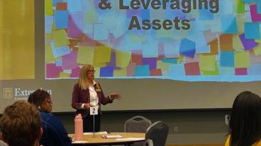 person presenting in front of large screen