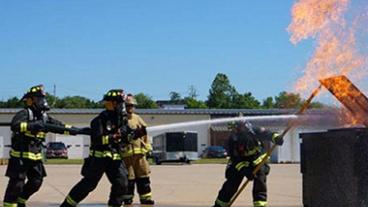 Fire fighters putting out a dumpster fire.