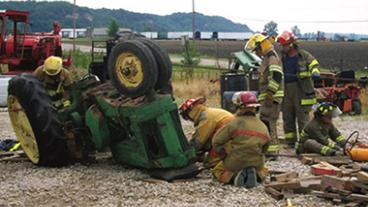 Fire fighters working a tractor accident rescue.