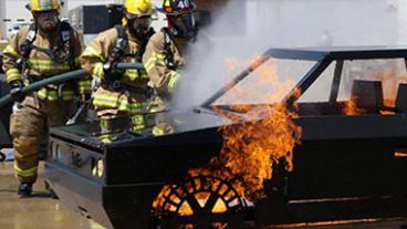 Fire fighters putting out a fire on a training vehicle.