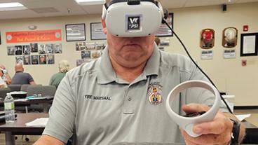 Man with a virtual reality headset on in a classroom.