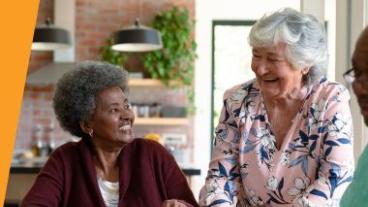 Two elderly women smiling and laughing together
