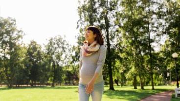 Pregnant woman walking in a park