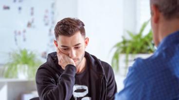 A man sitting with his chin on his hand.