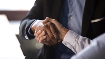 Close-up of handshake between 2 people in business attire