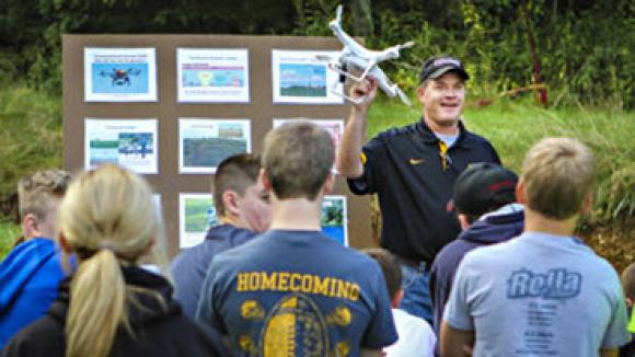 A man gives a presentation with a drone for students.
