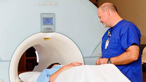 A doctor talking to a patient about to go into an MRI machine.