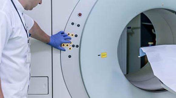 Man standing by an MRI machine.