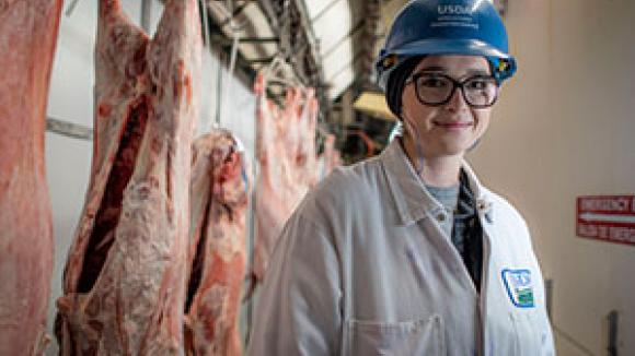 woman worker in front of meat being processed