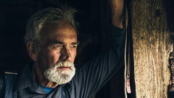 man gazing out of window