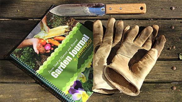 garden journal on table with gloves