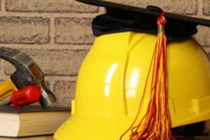 construction hat with graduation cap on top