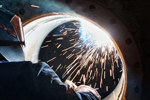 person welding a large pipe