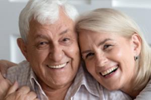 older couple embracing and smiking