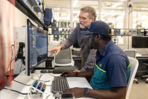 man showing another man computer skills